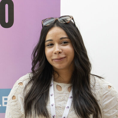 Jeune femme avec lunettes relevées, devant un kakémono violet