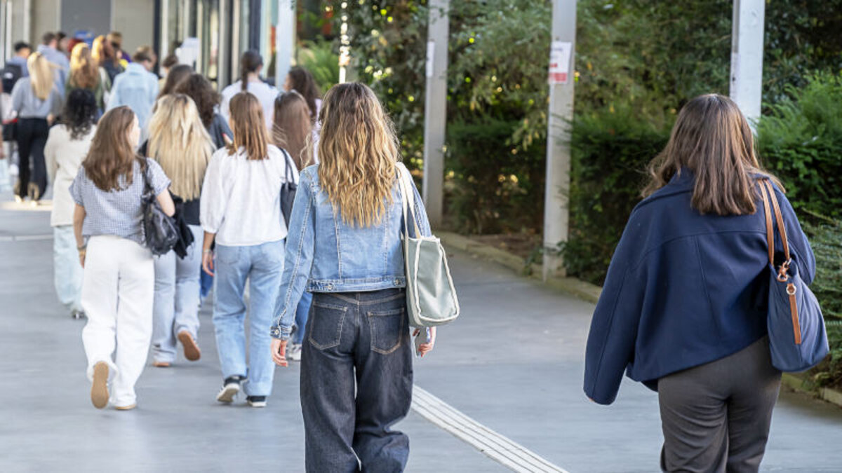 Étudiantes en train de marcher sur un campus, de dos.