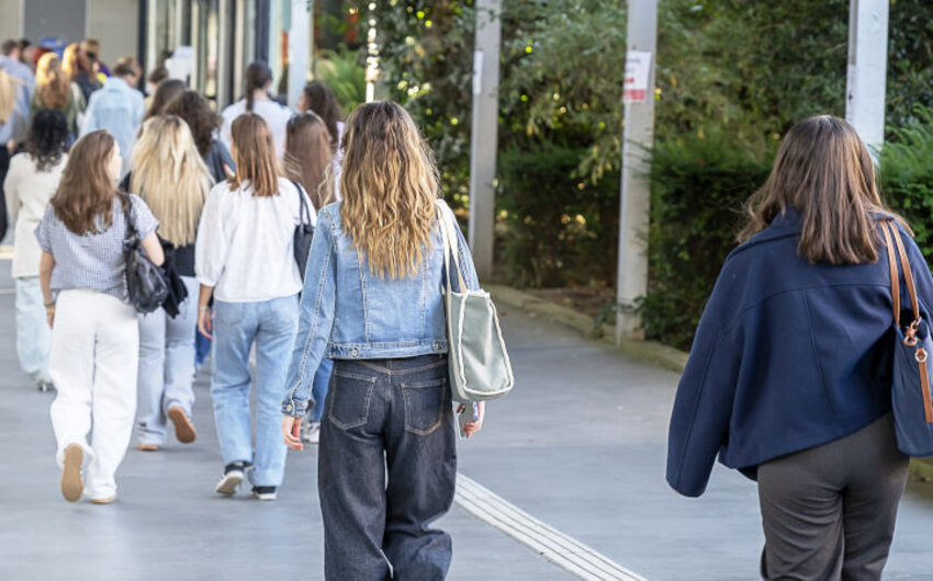 Étudiantes en train de marcher sur un campus, de dos.