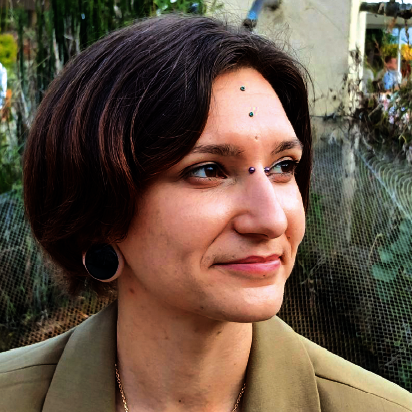 Visage d’une jeune femme souriant regardant à sa gauche.