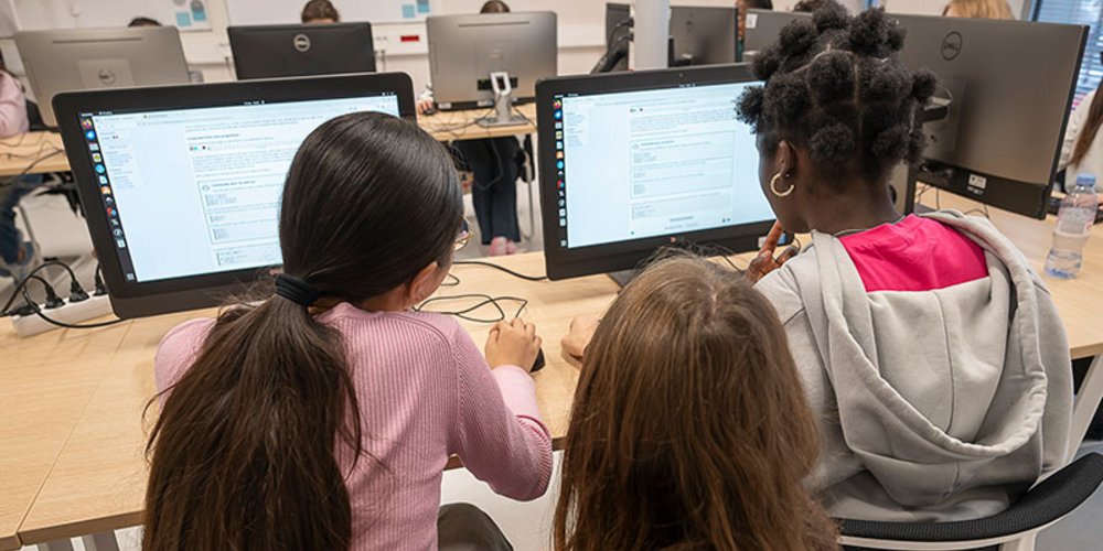 Deux jeunes filles face à des écrans d’ordinateur