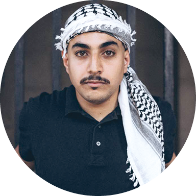 Un jeune homme avec un keffieh fixe l’objectif.