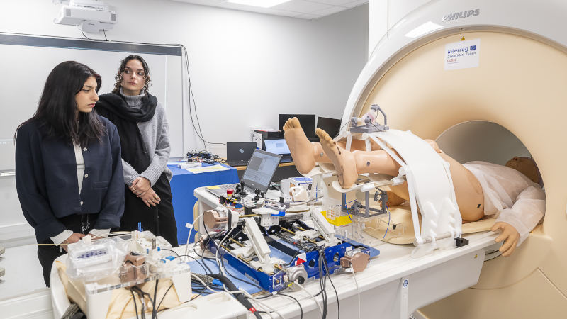 2 jeunes filles à côté d’un IRM dans lequel se trouve un mannequin